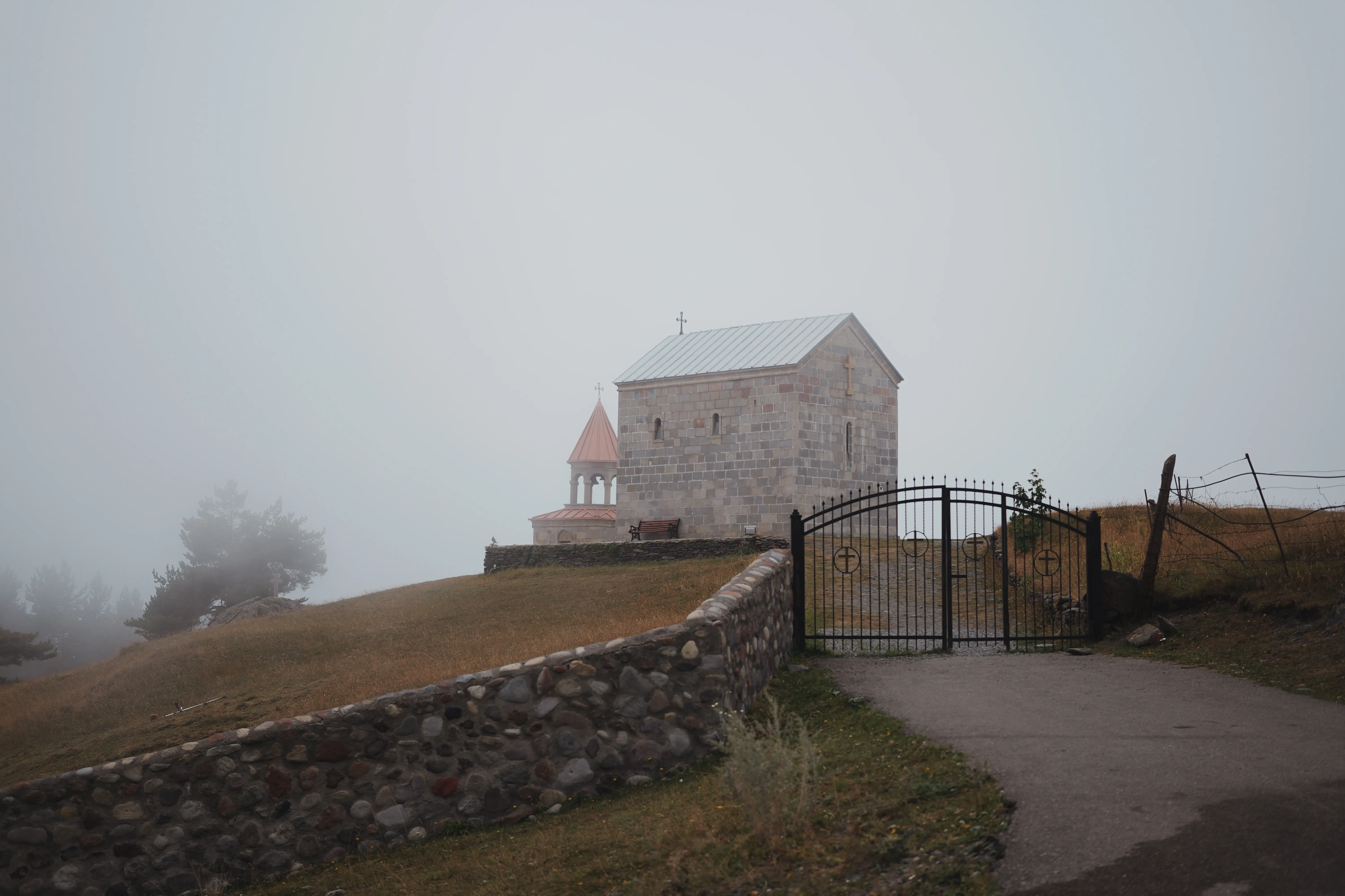 A stone church behind an iron gate
